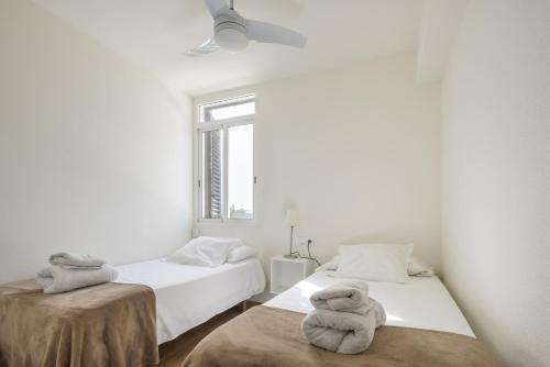 a white room with two beds and a window at Fantastic beach apartment near Valencia in Valencia