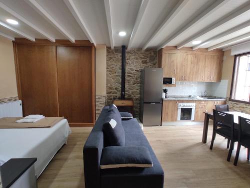 a living room with a couch and a kitchen at Mar de Nubes Piornal 1 in Piornal