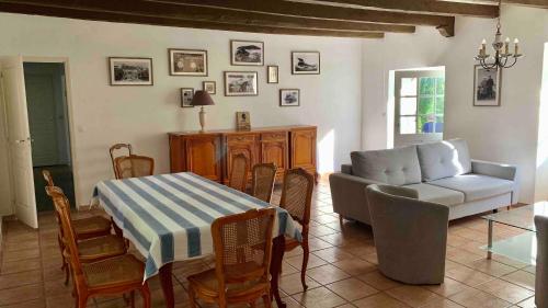 un salon avec une table et un canapé dans l'établissement Gîte de la Bergerie de Trémohar, à Berric