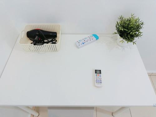 a table with a remote control and a plant on it at 12Pax BM 大山脚 Double-storey Autocity Alma Aeonjusco in Bukit Mertajam
