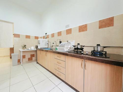 a kitchen with a counter with pots and pans on it at 12Pax BM 大山脚 Double-storey Autocity Alma Aeonjusco in Bukit Mertajam