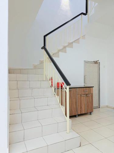 a staircase in a room with white tiles at 12Pax BM 大山脚 Double-storey Autocity Alma Aeonjusco in Bukit Mertajam