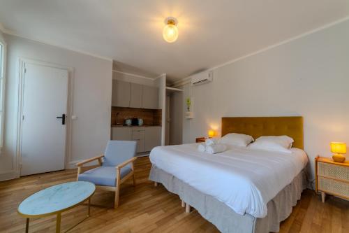 - une chambre avec un grand lit blanc et une chaise bleue dans l'établissement Majestic Suite, à Paris