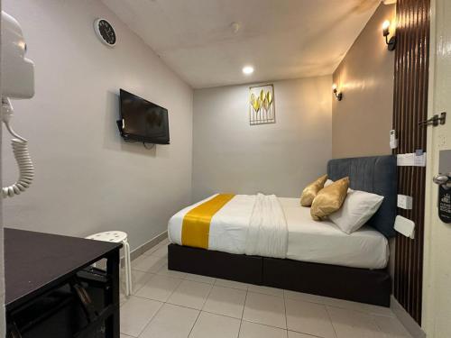 a small bedroom with a bed and a television at SS Grey Hotel kl in Kuala Lumpur