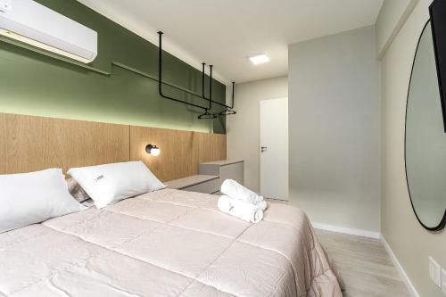 a bedroom with a large bed with two pillows at Apartamento Wunderhaus Luxo by Achei in Canela