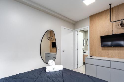 a bedroom with a bed and a mirror at Apartamento Wunderhaus Luxo by Achei in Canela