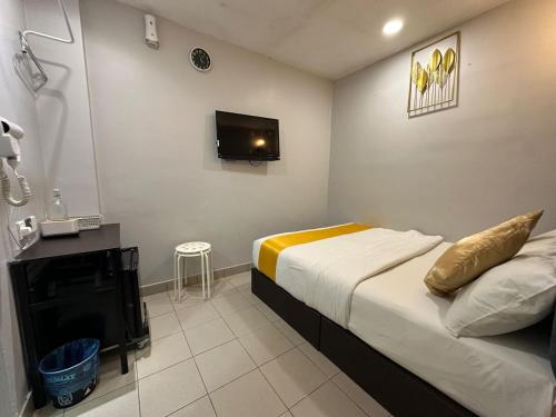 a small bedroom with a bed and a tv at SS Grey Hotel kl in Kuala Lumpur