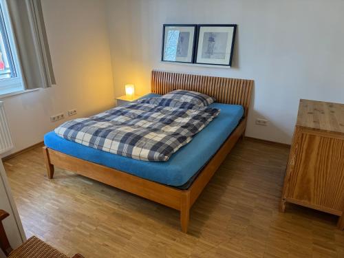 a bedroom with a bed with a plaid blanket on it at K9 Wohnungen in Münster