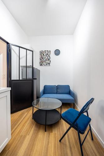 un salon avec un canapé bleu et une table en verre dans l'établissement 1#Cosystudio#Paris13#JardinDesPlantes, à Paris