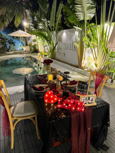 a table in front of a pool with red lights at Malis Homestay in Trà Vinh