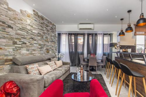 un salon avec un canapé et un mur en pierre dans l'établissement Gold Queen, à Cannes