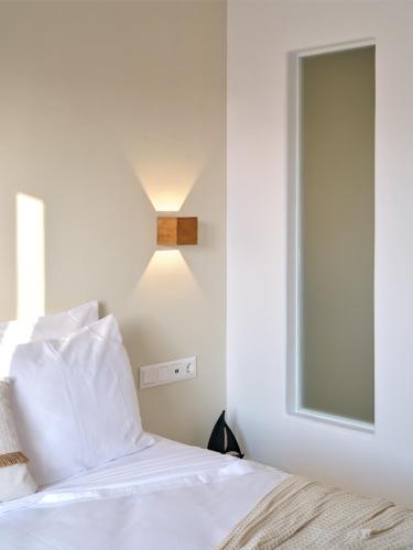 a bedroom with a bed with a light on the wall at Marjay Boutique in Parikia