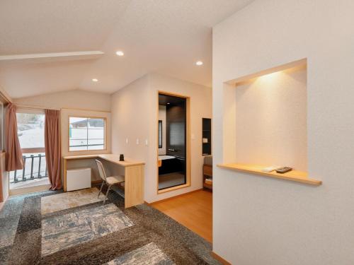 a living room with a desk and a bedroom at Hakuba Sun Valley Hotel in Hakuba