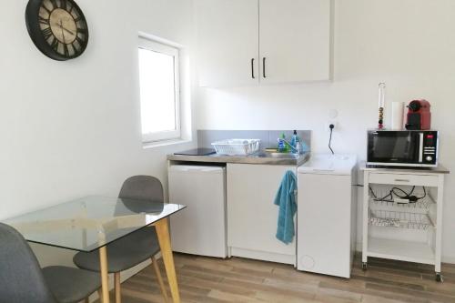 une petite cuisine avec une table et un micro-ondes dans l'établissement Nice subplex apartment - 2 people - Metro Mermoz-Parc Parilly, à Bron