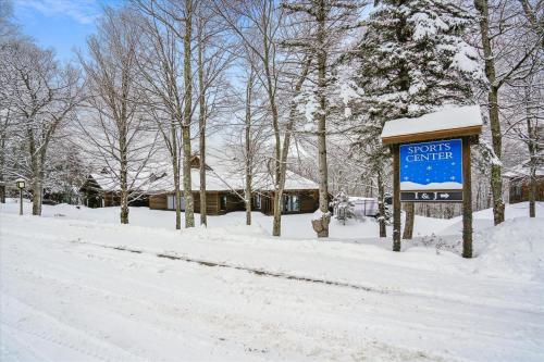 a sign in the snow in front of a house at Highridge B16A Inviting Queen Room for Two with Access to Pool and Hot Tub in Killington