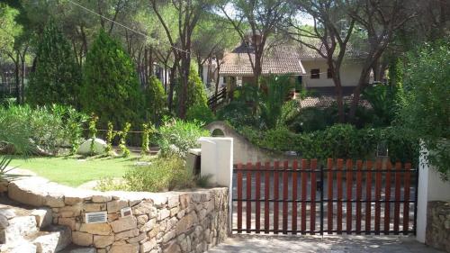a fence in front of a house with a yard at Villa Pina 100 meters from the sea in Fort Village