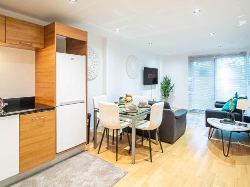 a kitchen and living room with a table and a couch at Leeds Dock 2BDR 2BA Balcony & River View in Leeds