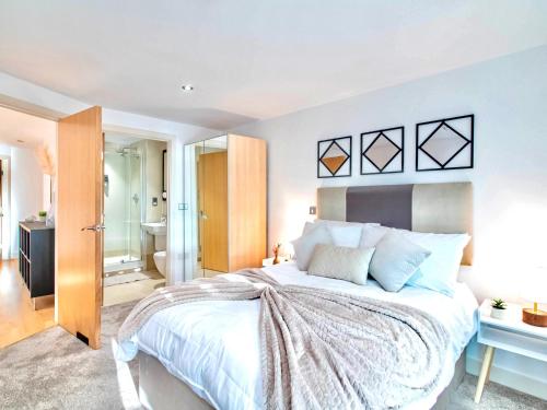 a bedroom with a large bed and a bathroom at River View 2-Bed Apartment with Balcony Leeds Dock in Leeds
