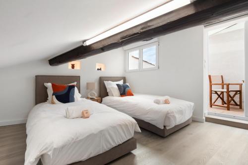 Ce lit se trouve dans un dortoir doté de murs blancs et d'une fenêtre. dans l'établissement Suquet Lovers- centre historique, à Cannes