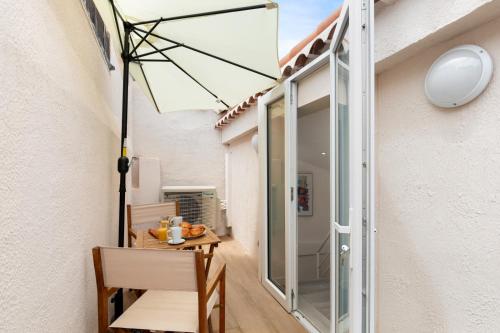 un patio avec une table et un parasol dans l'établissement Suquet Lovers- centre historique, à Cannes