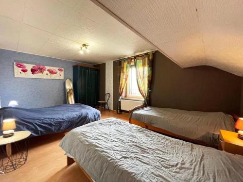 - une chambre avec 2 lits et une table dans l'établissement Charmant appartement à Le Val-d'Ajol avec terrasse, à Le Val-dʼAjol