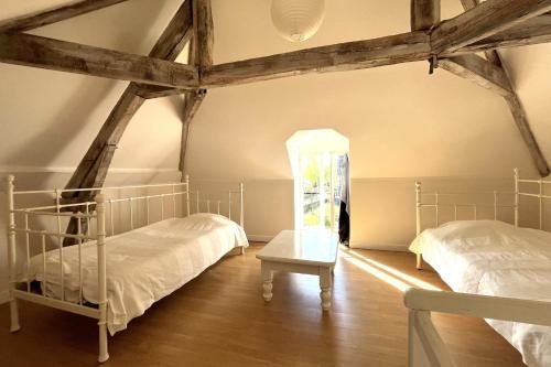 - 2 lits dans une chambre dotée de poutres en bois dans l'établissement L’Atelier du Valet, à Vigoux
