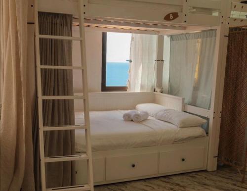 a white bunk bed with a teddy bear on it at Casanaga in Almáciga