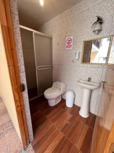 a bathroom with a toilet and a sink at Hostal Cactus in Cusco