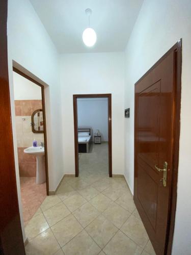 a hallway with a door and a sink and a bathroom at Home Majka in Sarandë
