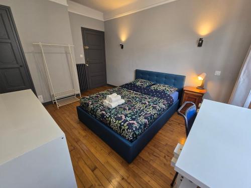 - une petite chambre avec un lit bleu et une table dans l'établissement Appartement cosy à l'Harteloire, à Brest