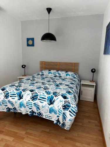 sypialnia z łóżkiem z niebiesko-białą kołdrą w obiekcie Loft luminoso Alcorcón M-40 Madrid w mieście Alcorcón