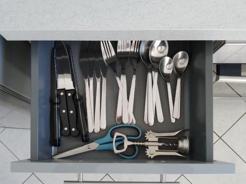 un tiroir rempli d'ustensiles assis sur un comptoir dans l'établissement Downtown Apartment, à Caen