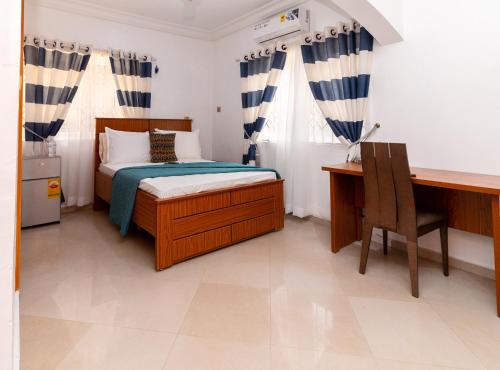 a bedroom with a bed and a desk and a computer at Ashanti Heritage Lodge in Kumasi