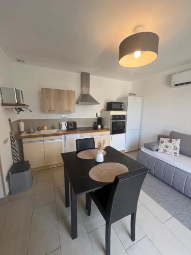 une cuisine et un salon avec une table et un canapé dans l'établissement Studio cosy avec climatisation et terrasse, à Malataverne