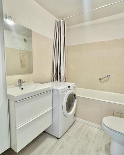 une salle de bain blanche avec une machine à laver à l'intérieur dans l'établissement Côté Mer, à Le Touquet-Paris-Plage