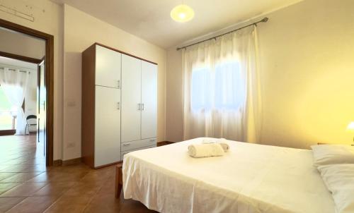 a bedroom with a white bed and a large window at Relax 5 minutes from the beach in Schifoni