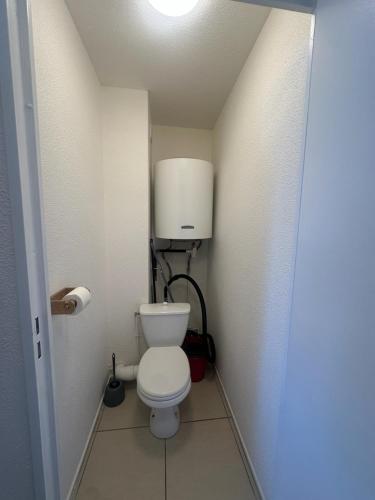 - une petite salle de bains avec des toilettes et un réservoir d'eau dans l'établissement T2 Bord de plage, résidence Bleu Marine 93, à Lacanau-Océan