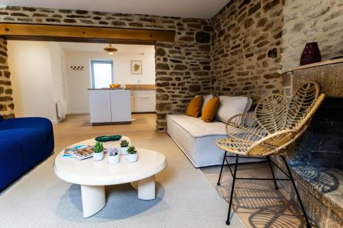un salon avec un canapé, une table et des chaises dans l'établissement L'Evasion Bretonne - Superbe T3 - Centre Ville - Balnéo, à Quimper