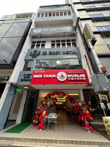 a store with a red sign in front of a building at SS Grey Hotel kl in Kuala Lumpur
