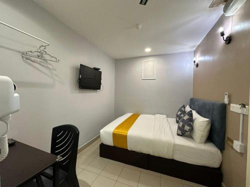 a small room with a bed and a tv at SS Grey Hotel kl in Kuala Lumpur