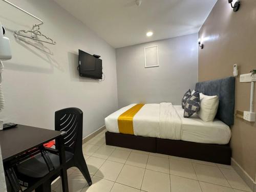 a small room with a bed and a table and a chair at SS Grey Hotel kl in Kuala Lumpur