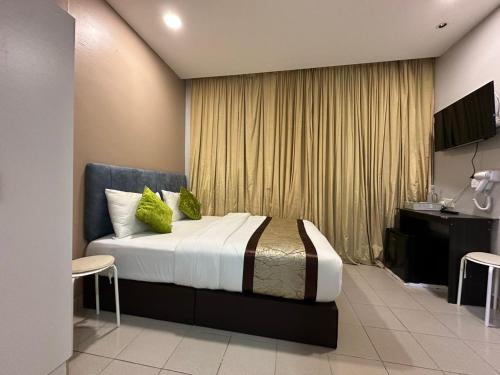 a bedroom with a large bed with green pillows at SS Grey Hotel kl in Kuala Lumpur