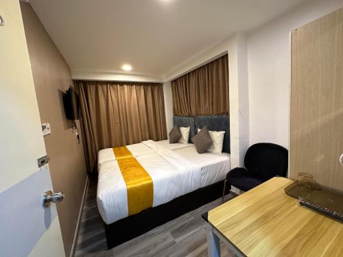 a hotel room with a bed and a desk at SS Grey Hotel kl in Kuala Lumpur