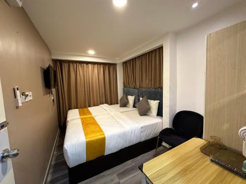 a hotel room with a bed and a desk at SS Grey Hotel kl in Kuala Lumpur
