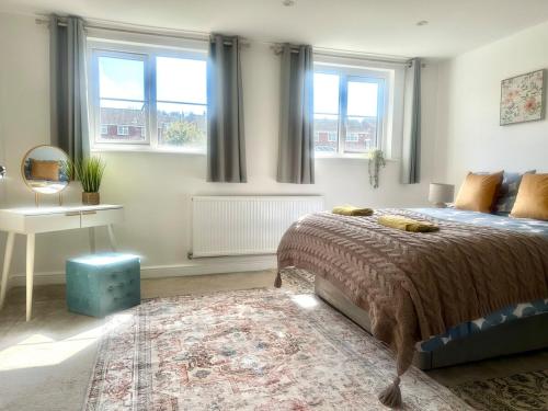 a bedroom with a bed and a table and windows at Five bedroom family house in St. Leonards