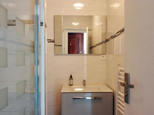 une salle de bain avec un lavabo et un miroir dans l'établissement Downtown Apartment, à Caen