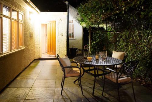 a table and chairs on a patio at night at Beach Approach Cottage - 30 steps from beach - Luxury house with covered table tennis - Netflix Smart TV in Filey