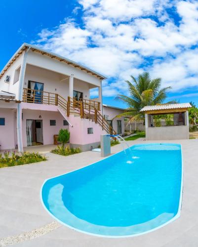 a villa with a swimming pool in front of a house at Recanto Berlin in Prado
