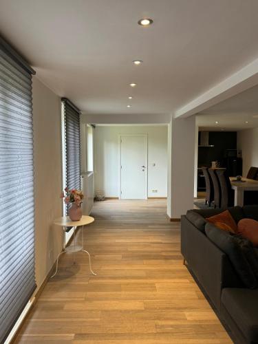 a living room with a couch and a table at mooie vakantiewoning bij BRUGGE in Damme