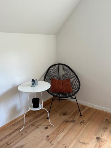 a chair and a table in a room at mooie vakantiewoning bij BRUGGE in Damme